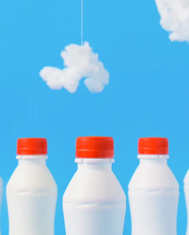 three milk bottles in a fake sky background.